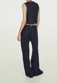 Marinblå rutig kort ärmlös topp med rak skärning, matchad med vida marinblå byxor med spänne och fickor.