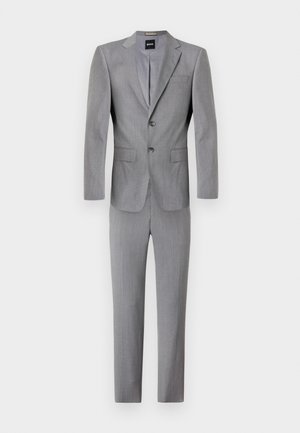 Costume gris comprenant une veste à deux boutons avec des revers crantés et un pantalon assorti, confectionné dans un tissu texturé. Coupe ajustée et design contemporain.