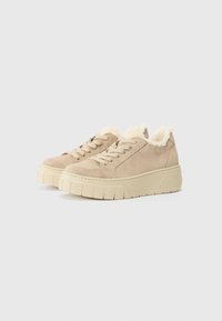 Beige suede sneakers with a textured, platform sole. Soft fur lining at the collar and a classic lace-up design. Flat, ridged outsole.