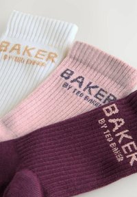 Zestaw trzech par skarpetek prążkowanych w kolorze białym, różowym i ciemnym burgundzie, z napisem "BAKER by TED BAKER" w kontrastowych kolorach.