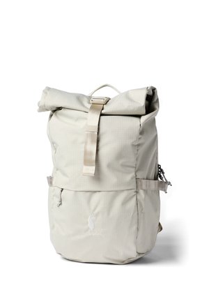 Light beige roll-top backpack with front buckle, zippered pocket, side straps, and a small logo near the bottom center.