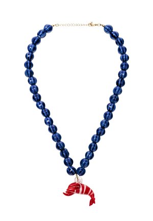 Halskæde med store, blanke mørkeblå perler og et vedhæng med en rød-og-hvidstribet delfin på en guldkæde med lukning.