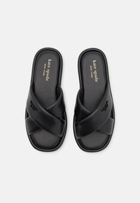 Svarte sandaler med kryssremdesign. Laget av glatt materiale, med gulllogo på innersålen og preget merkevare på siden.