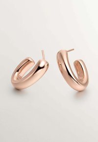 Pendientes de aro en oro rosa con un acabado suave y brillante y un diseño redondeado en forma de U. Incluyen postes de metal para un ajuste seguro.