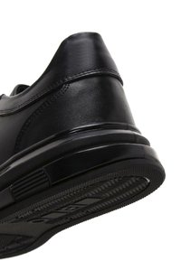 Sneaker in pelle nera con punta arrotondata e suola testurizzata. Presenta una parte superiore liscia, dettagli cuciti e una suola in gomma resistente.