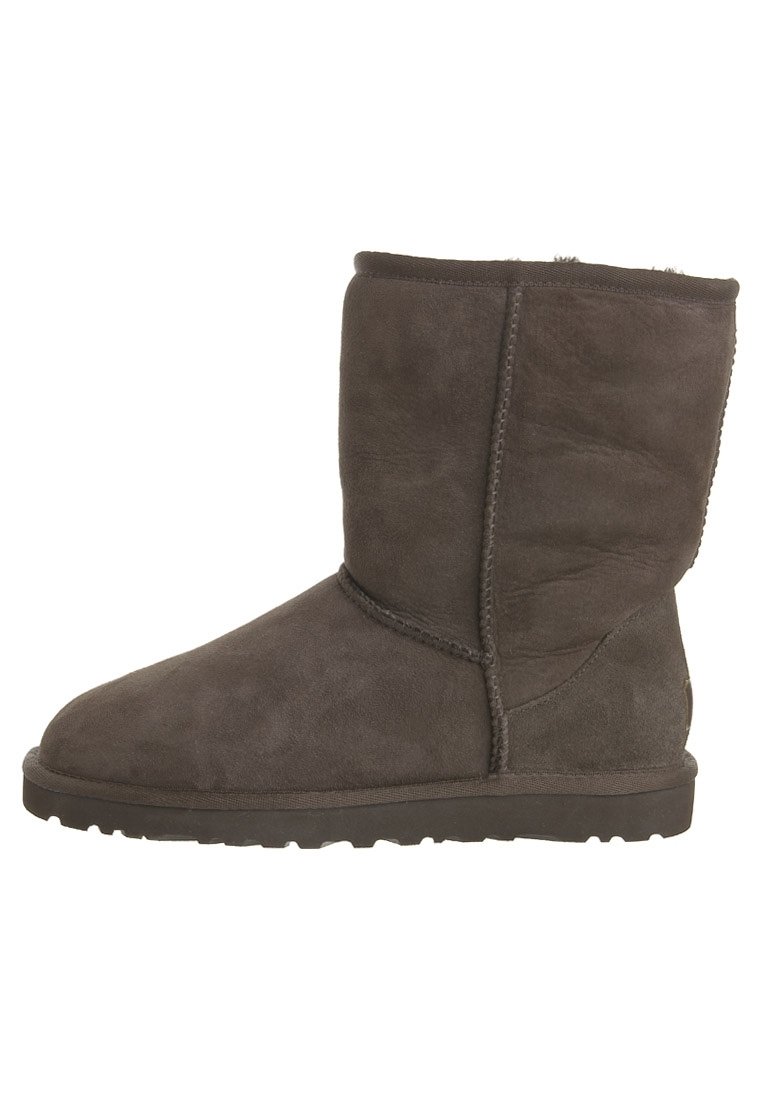 Botas de tobillo de ante marrón con punta redonda y suela plana de goma, con costuras cosidas y un forro interior suave.