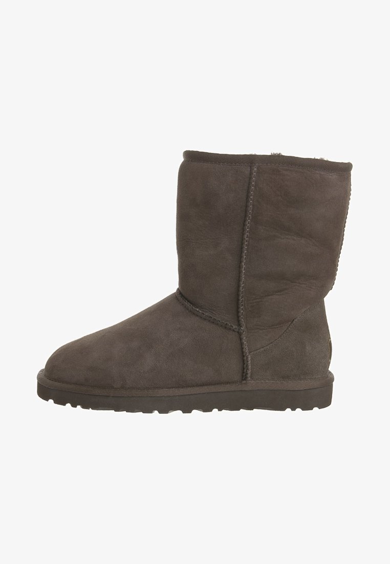 Botas de tobillo de ante marrón con punta redonda y suela plana de goma, con costuras cosidas y un forro interior suave.