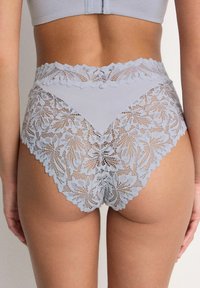 Chilot cu talie înaltă, de culoare albastru deschis, cu detalii intricate din dantelă florală, margini ondulate și o combinație de țesături netede în partea din față.