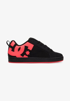 Baskets basses noires avec logo DC rouge vif sur le côté, semelle extérieure rouge assortie, fermeture à lacets et languette au talon.