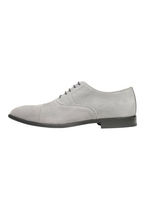 Scarpe da cerimonia in suede grigio con punta arrotondata, sei occhielli per lacci e suola in gomma nera. Presentano dettagli di cucitura sottili.
