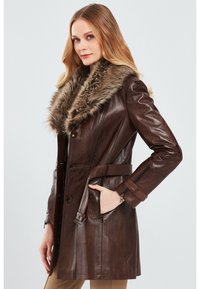 Brown leather coat featuring a faux fur collar, button front, belt detail, and zippered side pockets. Smooth texture with a tailored fit.