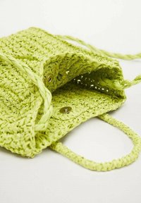 Sac vert tissé en matériau tressé avec deux poignées et fermetures à bouton. L'intérieur présente un design ouvert et une finition texturée.