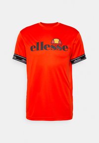 Rød kortærmet t-shirt lavet af letvægtsstof, med et fremtrædende sort "ellesse" logo og branding på de opkrøllede ærmer.