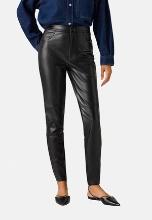 Pantalones de cuero negro con un diseño ajustado, textura suave y cintura alta. Con bolsillos frontales y cierre de botón.