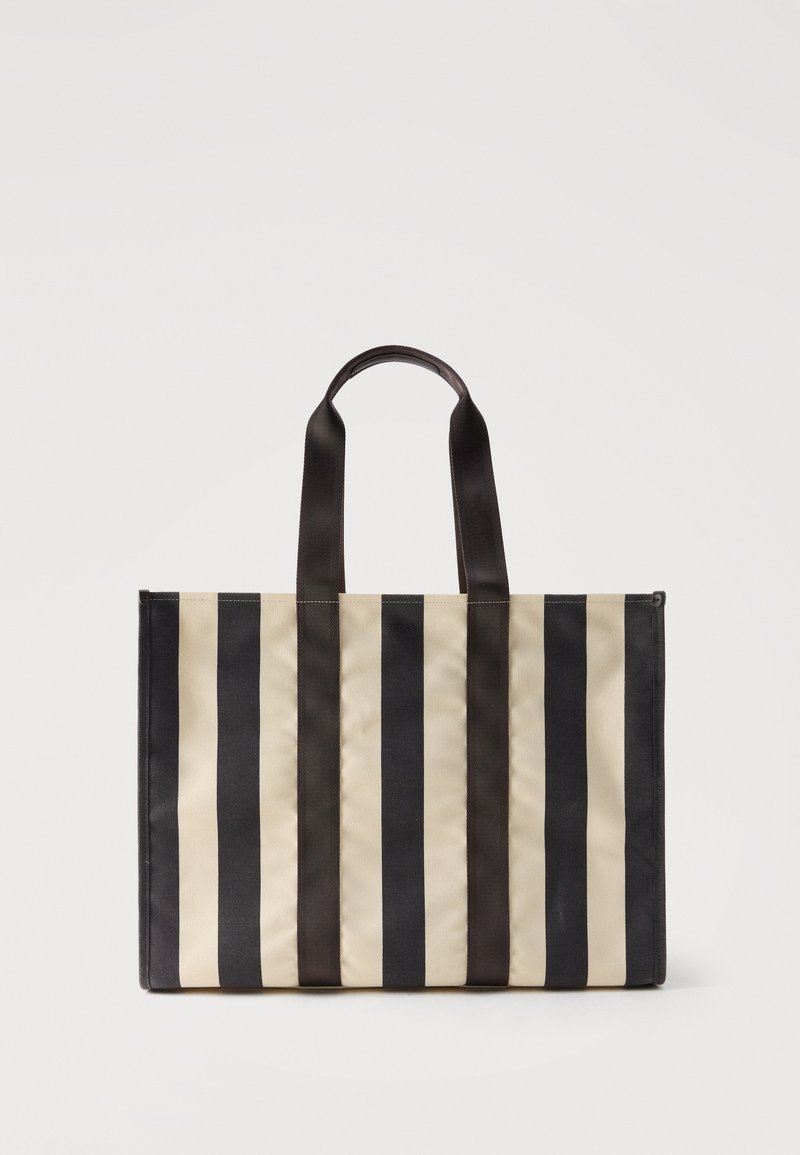 Τσάντα tote με κάθετες ρίγες σε μαύρο και μπεζ χρώμα, δύο μαύρες λαβές, ορθογώνιο σχήμα, όρθια σε λευκό φόντο.