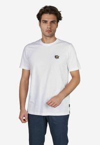 Weißes Baumwoll-T-Shirt mit einem kleinen blauen und gelben gestickten Sonnendesign auf der linken Brust, kurzen Ärmeln und Rundhalsausschnitt.