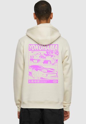 Beige hoodie featuring a large pink graphic on the back with car illustrations and "YOKOHAMA" text. Soft texture and adjustable hood.