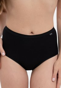 Mutande nere a vita alta realizzate in un morbido tessuto, con un elastico in vita liscio e un design minimalista senza motivi visibili.