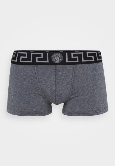Grey cotton boxer shorts with a black elastic waistband, featuring a Greek key pattern and a central emblem. Soft texture, fitted design.