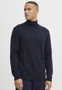 Navyblauwe coltrui van zachte gebreide stof, met lange mouwen en een getailleerd ontwerp met ribgebreide manchetten en zoom.