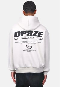 Sweat à capuche blanc avec un grand imprimé noir au dos, comprenant du texte et un logo. Manches et taille ajustées, texture de tissu douce.