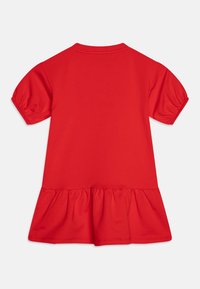 Rotes kurzärmliges Kleid für Kleinkinder mit gerafften Puffärmeln und einem Volant-Saum, von hinten auf einem weißen Hintergrund gezeigt.