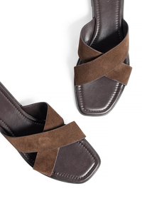 Bruine suède sandalen met een kruislings ontwerp, vierkante neus en gladde donkerbruine zolen. Verfraaid met subtiele stiksels.