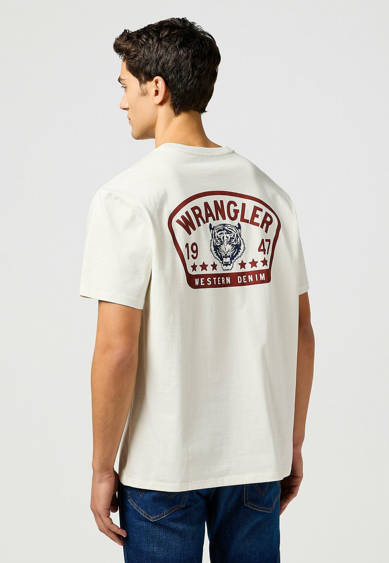Herrecreme bomulds t-shirt med rund hals, der har et grafisk tryk af en tiger og "WRANGLER 1947 WESTERN DENIM" på ryggen.