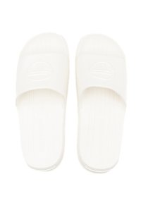 White slide sandals with a smooth finish, featuring a wide strap and logo detail. The sole has ridges for grip. Simple, minimalist design.