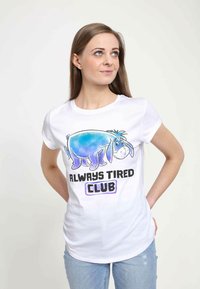 Bílý bavlněný tričko s barevným obrázkem Eeyora a textem "ALWAYS TIRED CLUB" v černém a fialovém písmu. Krátké rukávy.