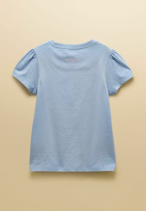 Vaaleansininen vauvan lyhythihainen paita, jossa on liehukehihat ja "Joules" kirjailtuna vaaleanpunaisella yläselässä.