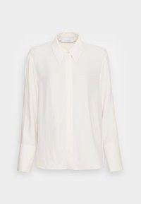 White long-sleeve blouse with pointed collar, hidden button placket, and wide cuffs, displayed on a neutral background.