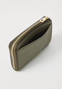 Olive green zip-around wallet in smooth material, featuring a gold-tone zipper, exterior card slots, and a streamlined shape.