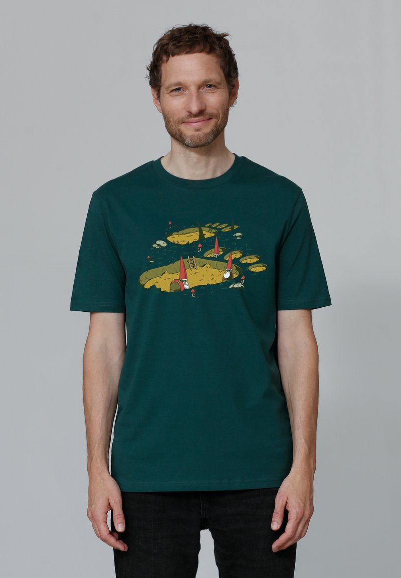 T-shirt en coton vert foncé avec un graphique coloré de gnomes, d'arbres et d'eau, à coupe décontractée et col rond.