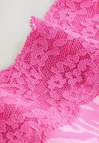 Țesătură roz din dantelă cu un model floral complicat, având o textură delicată și o margine zimțată. Aspect ușor și aerisit.