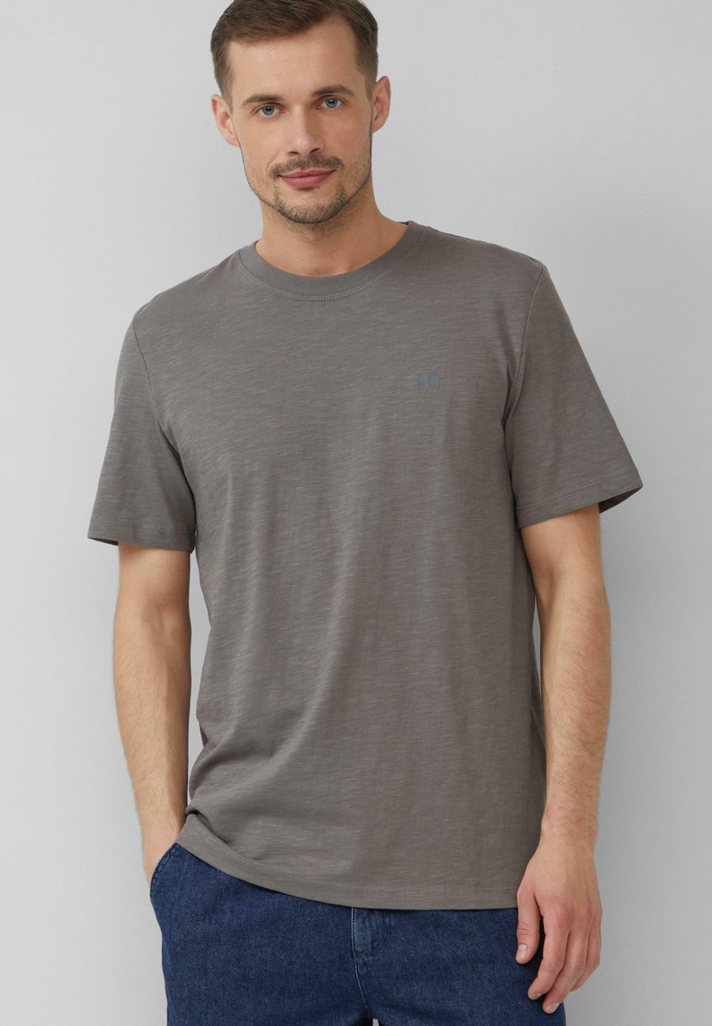 Grijs shirt met korte mouwen van een zachte, gestructureerde stof. Beschikt over een ronde hals en een klein, lichtblauw logo op de borst.