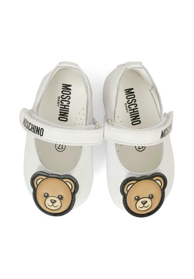 Scarpine bianche in pelle per bambini, stile Mary Jane, con un'applicazione a forma di faccina di orsetto nero e marrone sul davanti e una fascia in velcro.