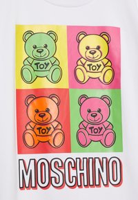 White t-shirt featuring a colorful graphic of four cartoon teddy bears in green, yellow, orange, and pink, labeled "Toy," with bold "MOSCHINO" text below.
