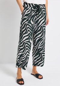 Grüne und weiße Zebra-Muster weit geschnittene Hosen, aus leichten Stoff mit elastischem Bund und Kordelzug. Mit Seitentaschen.