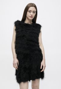 Μαύρο φόρεμα χωρίς μανίκια από υλικό με υφή, που μοιάζει με χνουδωτή γούνα, με κυματιστά οριζόντια πάνελ και ευθεία κοπή στο τελείωμα.