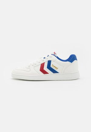 White low-top sneaker with blue and red chevron stripes, blue padded collar, white laces, and "hummel handball perfekt" logo on side.