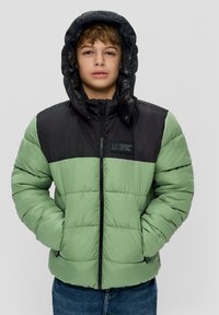 Puchowa kurtka z czarną górną częścią i zieloną dolną częścią, na zamek, z kapturem i naszywką z logo na klatce piersiowej. Teksturowany materiał.