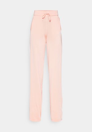 Peach-colored sweatpants made of soft fabric, featuring a drawstring waistband, side pockets, and a simple logo on the left side.