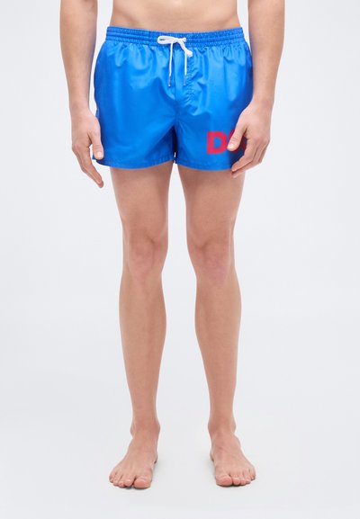 Shorts de bain bleus avec une taille élastique, un cordon de serrage blanc, et un grand "D" rouge sur la cuisse gauche. Matière lisse et légère.