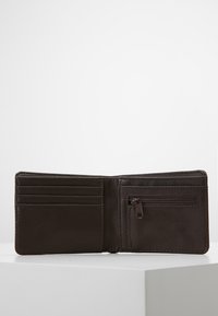 Portafoglio in pelle marrone aperto per mostrare diverse fessure per carte e una tasca con zip, caratterizzato da una texture liscia e un design semplice.