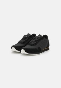 Black athletic shoes with a blend of smooth synthetic and textured suede materials. Features a lace-up design and white speckled rubber sole.