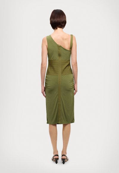 Robe verte olive ajustée avec un design à une épaule, présentant des détails en côtes verticales et un zip central dans le dos.