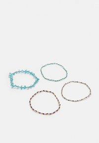 Set med fyra armband: ett med blå stenar, tre med små flerfärgade pärlor; olika former och färger, alla i flexibla material.