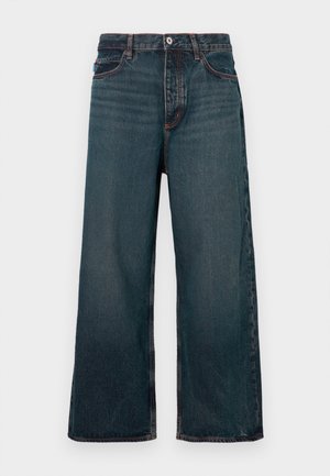 Jeans di jeans a gamba larga blu scuro con chiusura frontale con bottoni, zip e design a cinque tasche, mostrati su sfondo bianco.