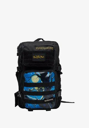 Sac à dos noir avec logo de groupe et patch "Fear of the Dark". Le devant présente un graphique bleu d'un personnage avec des bretelles et du matériel noir.